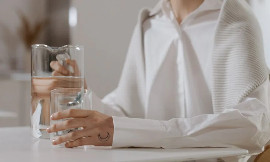 물이 담긴 잔을 들고 있는 손